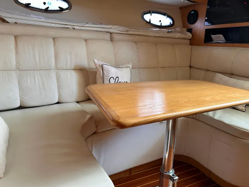 Slide: The Image of 1998 Tiara Yachts 3500 Open interior with cushioned seating and wooden table. - 13