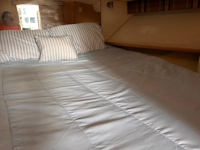 Slide: The Image of 1998 Tiara Yachts 3500 Open cabin interior with bed and striped pillows. - 14