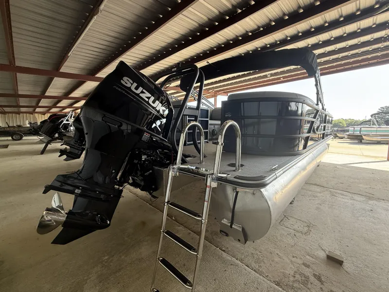 Slide: The Image of 2025 Bentley Pontoons Legacy Navigator 243 with Suzuki engine in covered storage. - 5