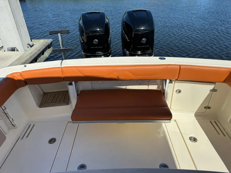 Slide: The Image of 2017 Scout 320 LXF boat interior with tan seating and dual outboard engines. - 10