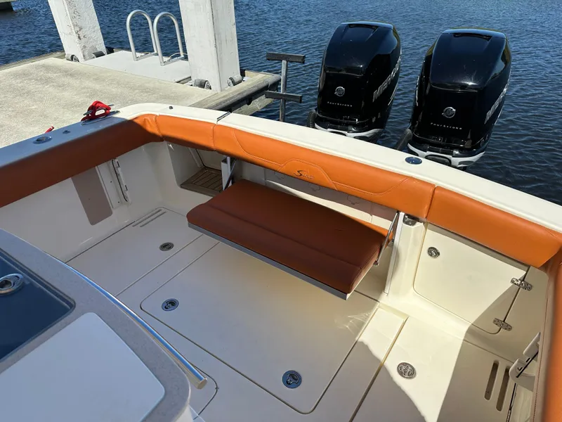 Slide: The Image of 2017 Scout 320 LXF boat interior with tan seating and dual Mercury outboard engines. - 11