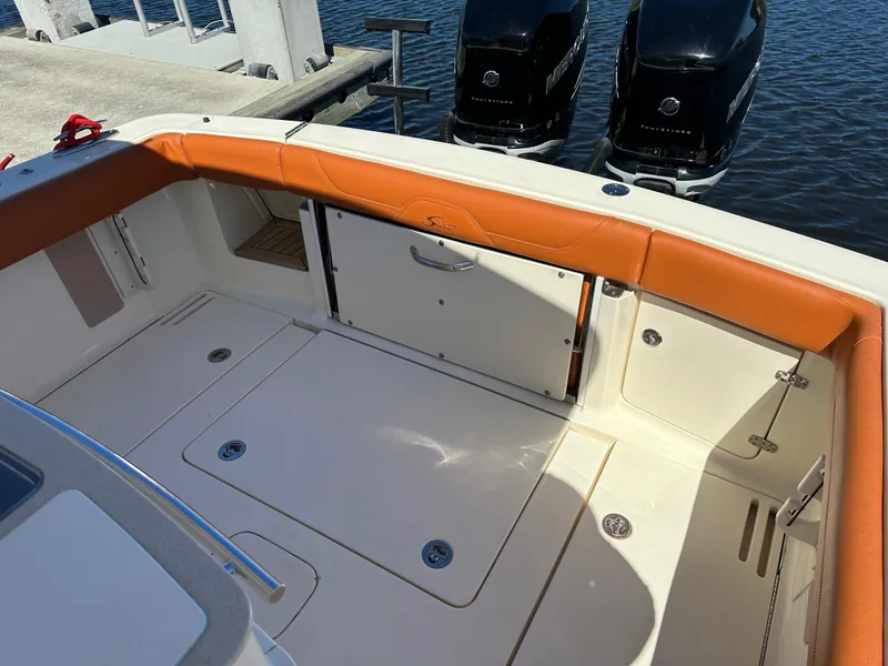 Slide: The Image of 2017 Scout 320 LXF boat interior with orange seating and dual Mercury outboard engines. - 12
