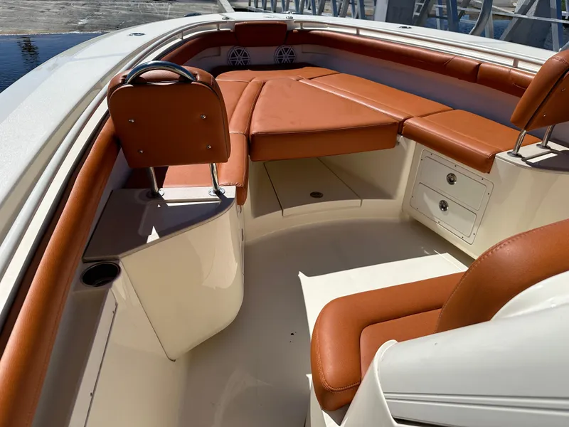 Slide: The Image of 2017 Scout 320 LXF boat interior with brown leather seating and storage compartments. - 14