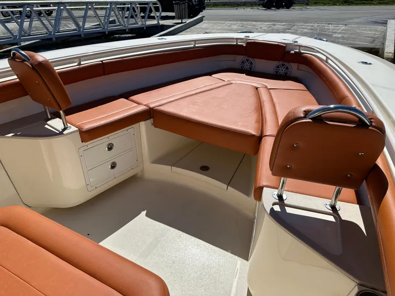 Slide: The Image of 2017 Scout 320 LXF boat interior with tan leather seating and storage compartments. - 15