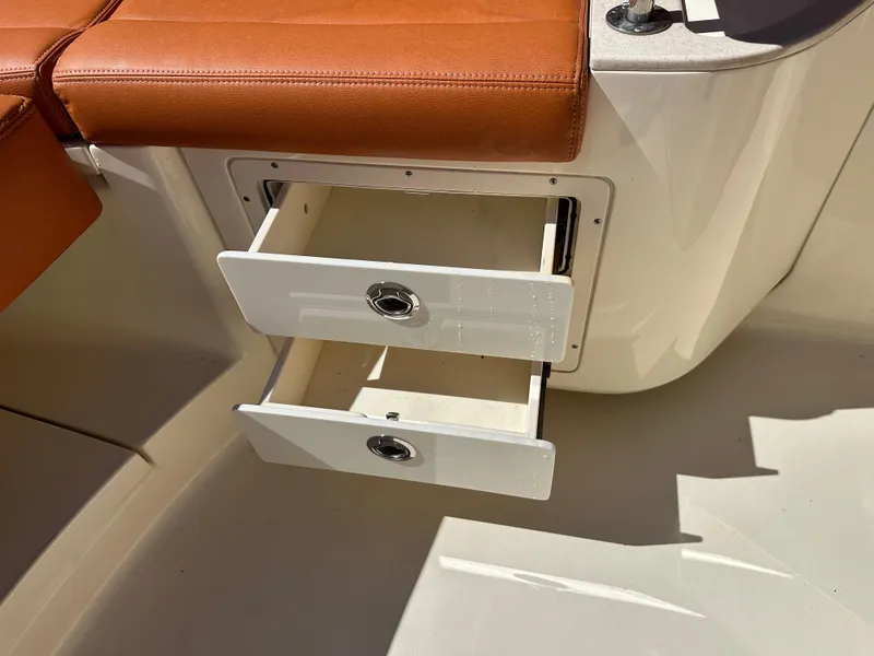 Slide: The Image of Open storage drawers on a 2017 Scout 320 LXF boat with brown seating. - 23