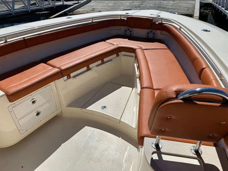 Slide: The Image of 2017 Scout 320 LXF boat interior with brown leather seating and storage compartments. - 24