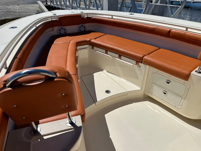 Slide: The Image of 2017 Scout 320 LXF boat interior with brown leather seating and storage compartments. - 25