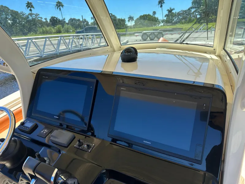Slide: The Image of 2017 Scout 320 LXF boat dashboard with dual Garmin displays and compass. - 28