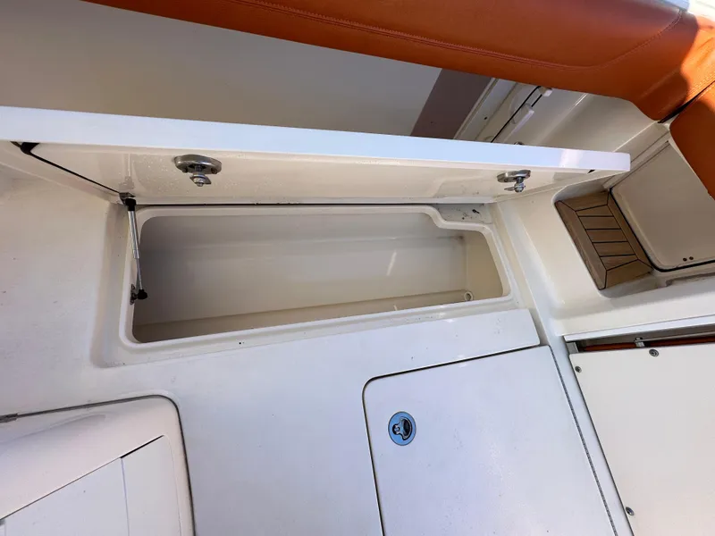 Slide: The Image of Open storage compartment on 2017 Scout 320 LXF boat with brown seating. - 34