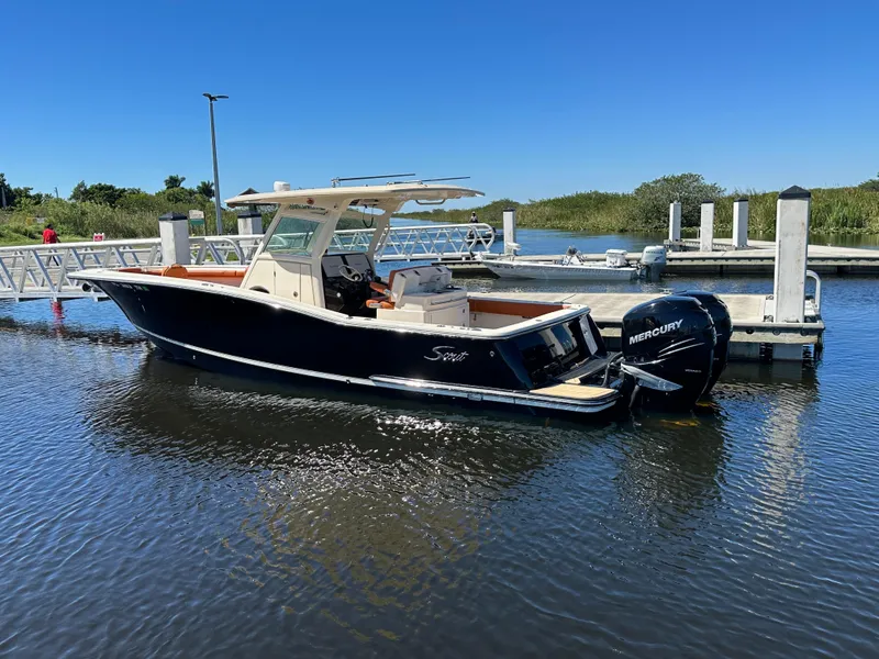 Slide: The Image of 2017 Scout 320 LXF boat docked with Mercury outboard engine. - 6