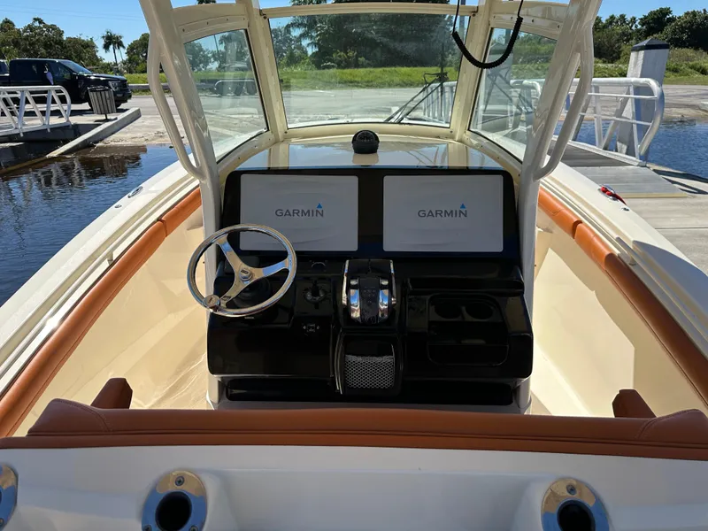 Slide: The Image of 2017 Scout 320 LXF boat dashboard with Garmin displays and steering wheel. - 7
