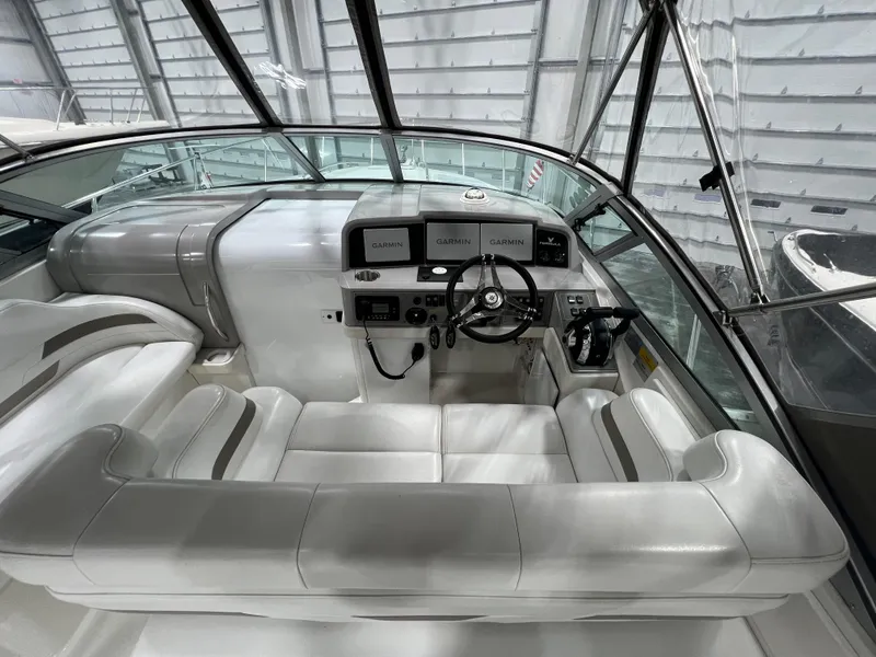 Slide: The Image of 2000 Formula 31 PC boat interior with white seating and control panel in a covered dock. - 11