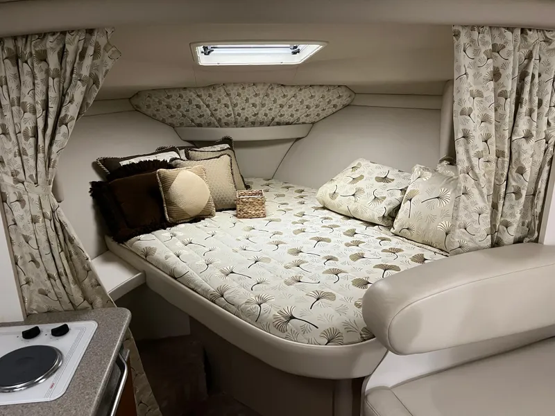 Slide: The Image of Cozy cabin interior of 2000 Formula 31 PC boat with patterned bedding and curtains. - 15
