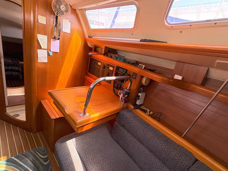 Slide: The Image of 2005 Hunter 38 sailboat interior with navigation station and seating area. - 17