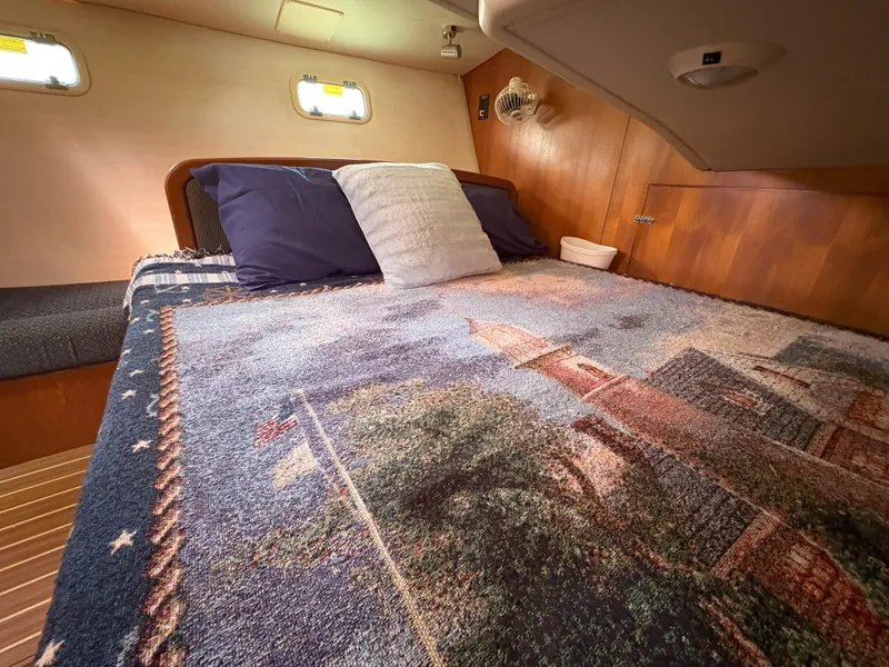 Slide: The Image of Cozy cabin interior of 2005 Hunter 38 sailboat with decorative bedding and wooden accents. - 20