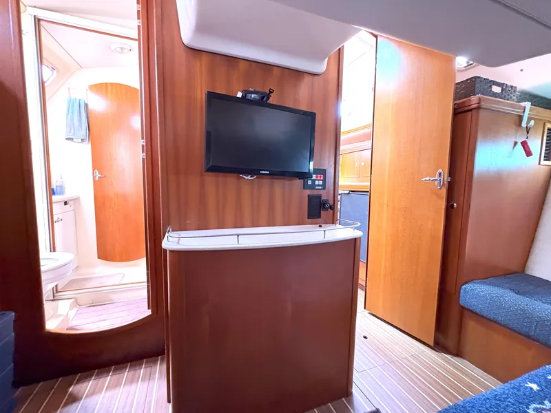 Slide: The Image of Interior of 2005 Hunter 38 yacht with TV, wooden cabinetry, and bathroom view. - 21
