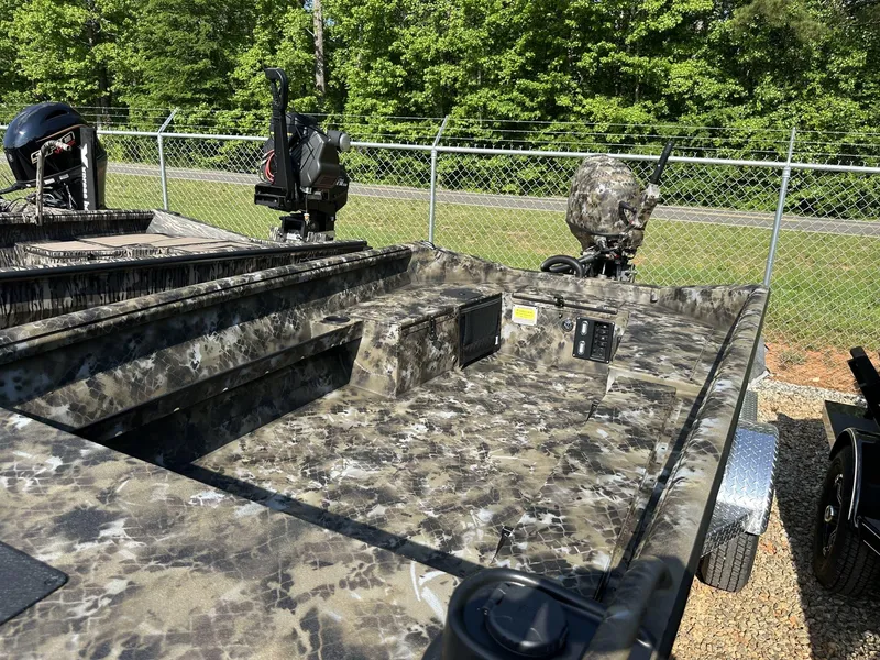 Slide: The Image of 2025 Excel Viper F4 1751 boat with camouflage design, parked near a chain-link fence. - 5