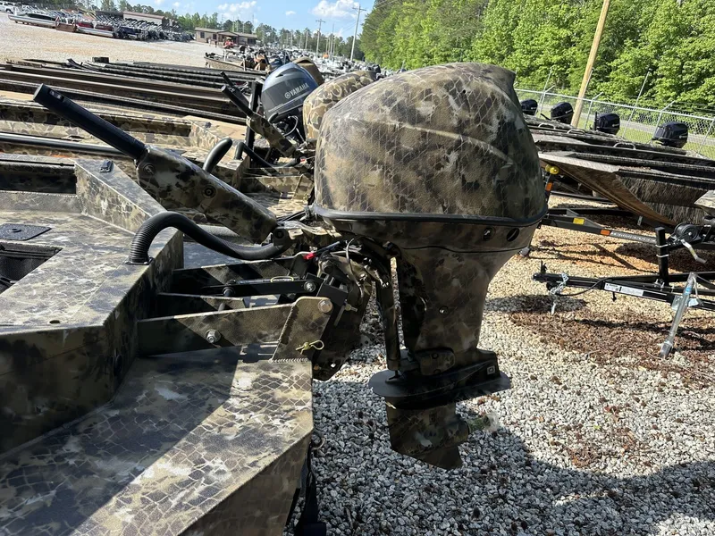 Slide: The Image of Camouflage-patterned Excel Viper F4 1751 boat motor, 2025 model, in a gravel lot. - 4
