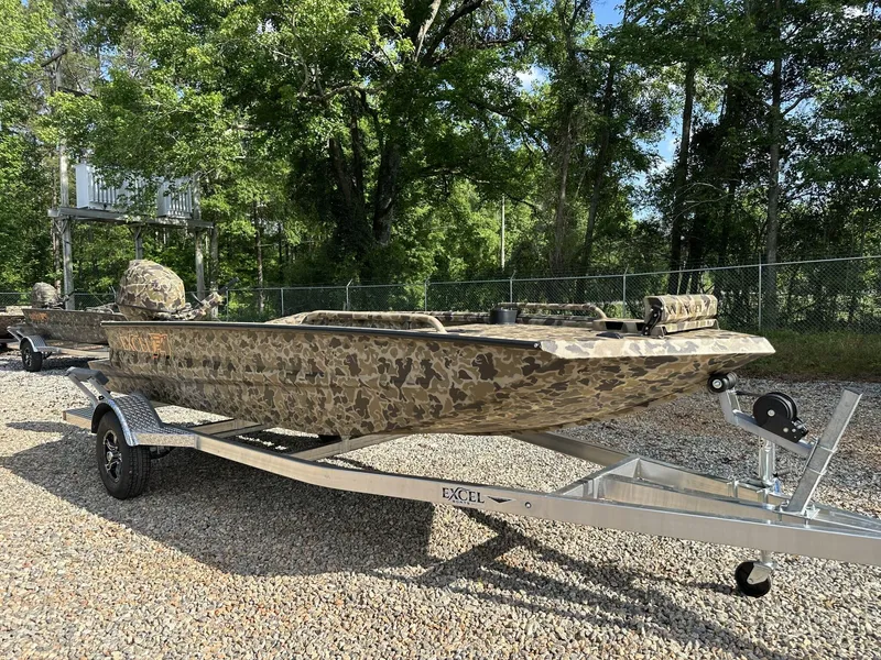 Slide: The Image of 2025 Excel Viper F4 1751 boat with camouflage design on a trailer, surrounded by trees. - 1