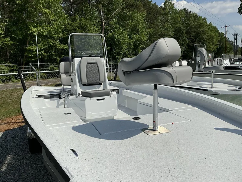 Slide: The Image of 2025 Xpress Hyper-Lift Series H22B boat with seating, outdoors, surrounded by trees. - 4