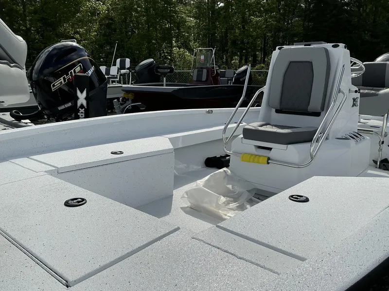 Slide: The Image of 2025 Xpress Hyper-Lift Series H22B boat interior with seating and motor, surrounded by trees. - 3