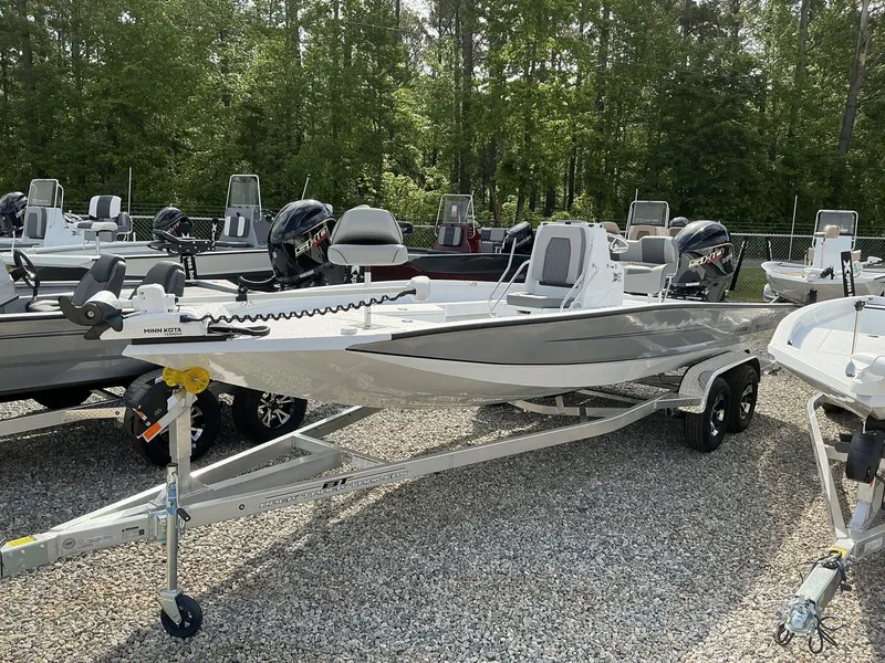 Slide: The Image of 2025 Xpress Hyper-Lift Series H22B boat on trailer, surrounded by trees and other boats. - 5