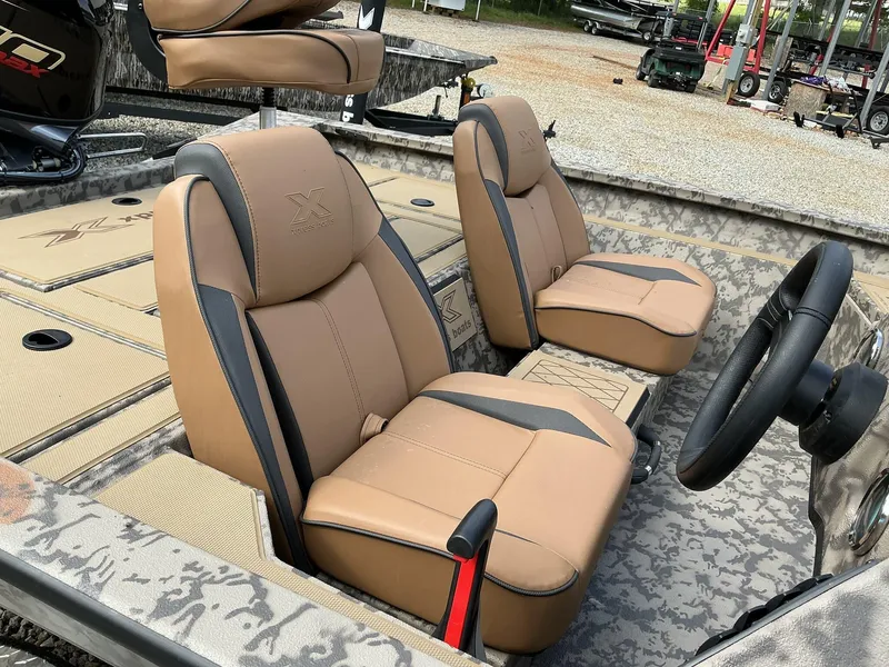 Slide: The Image of 2025 Xpress Hyper-Lift Bass Series boat interior with tan seats and steering wheel. - 6