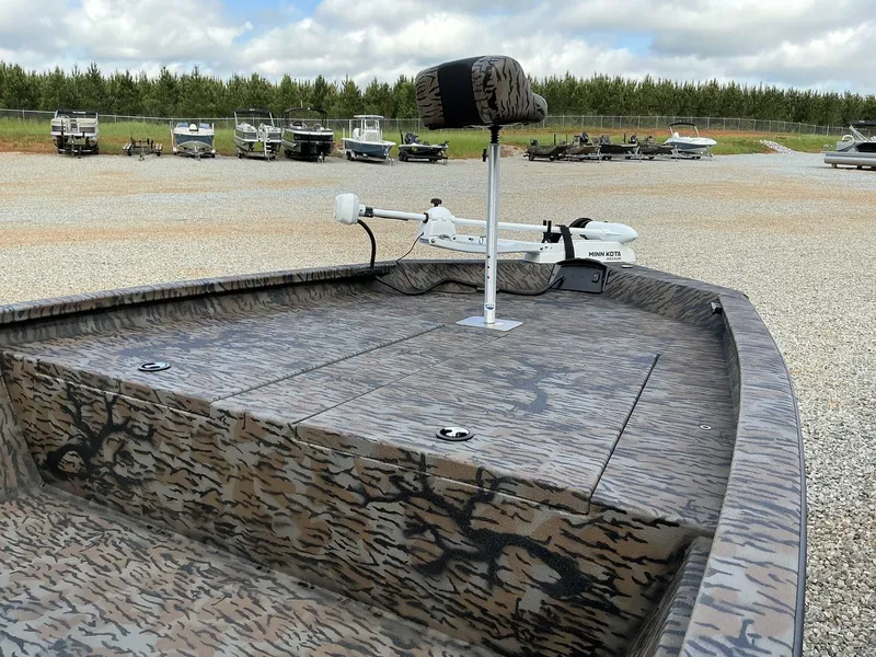 Slide: The Image of 2025 Xpress Hyper-Lift Bay Series 210 BAY-175 HP boat with camo design and Minn Kota trolling motor. - 2