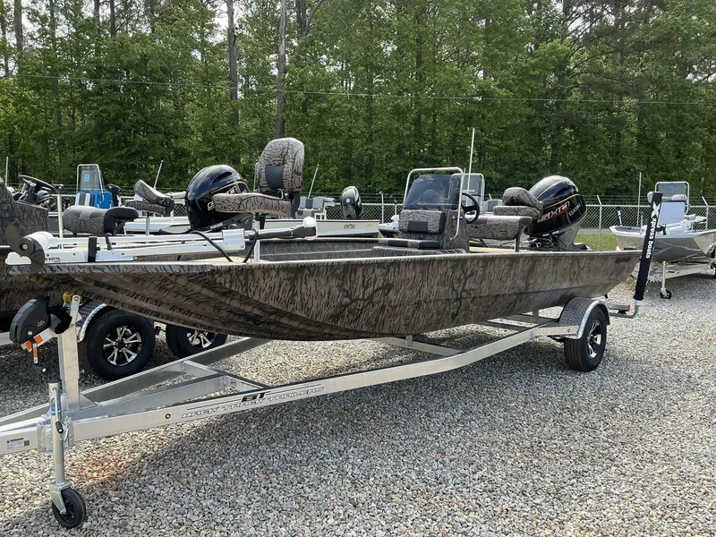 Slide: The Image of 2025 Xpress Xplorer Series XP20CC boat on trailer, camo design, parked outdoors. - 1