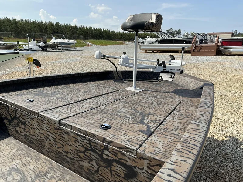 Slide: The Image of 2025 Xpress Hyper-Lift Bay Series 210 BAY-175 HP boat with camo design in a gravel lot. - 4