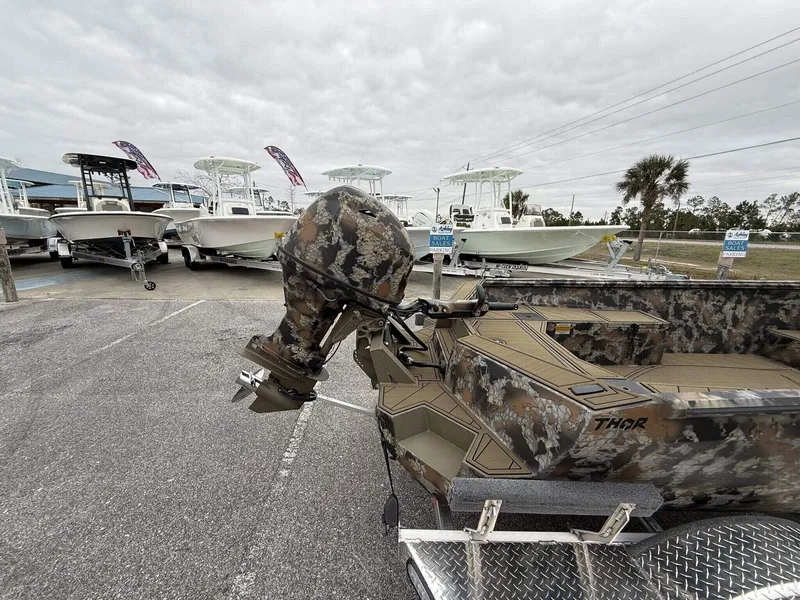 Slide: The Image of 2025 Thor Lake Hammer 1754 Timber Hammer boat with Seadeck, camo design, parked in a marina. - 3