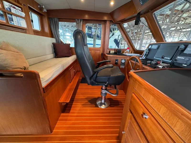 Slide: The Image of Interior of 2010 North Pacific 43 Pilothouse with wooden finish and captain's chair. - 10