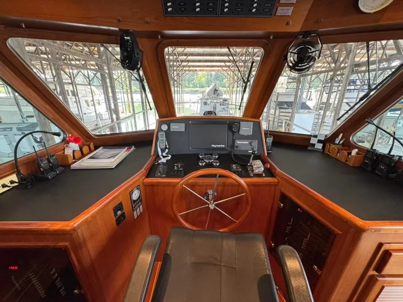 Slide: The Image of Pilothouse interior of 2010 North Pacific 43, featuring steering wheel and navigation equipment. - 11