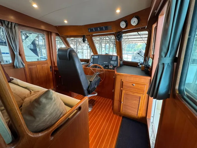 Slide: The Image of Pilothouse interior of 2010 North Pacific 43, featuring wood paneling and navigation equipment. - 13