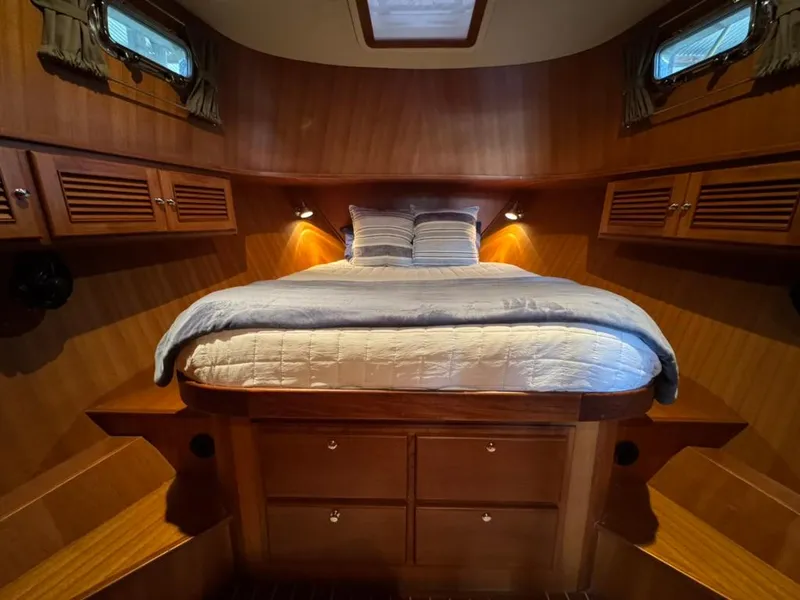 Slide: The Image of Cozy cabin interior of 2010 North Pacific 43 Pilothouse with wood finish and comfortable bedding. - 14