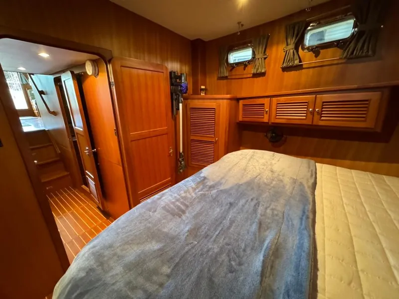 Slide: The Image of Cozy bedroom in 2010 North Pacific 43 Pilothouse yacht with wood paneling and porthole windows. - 15