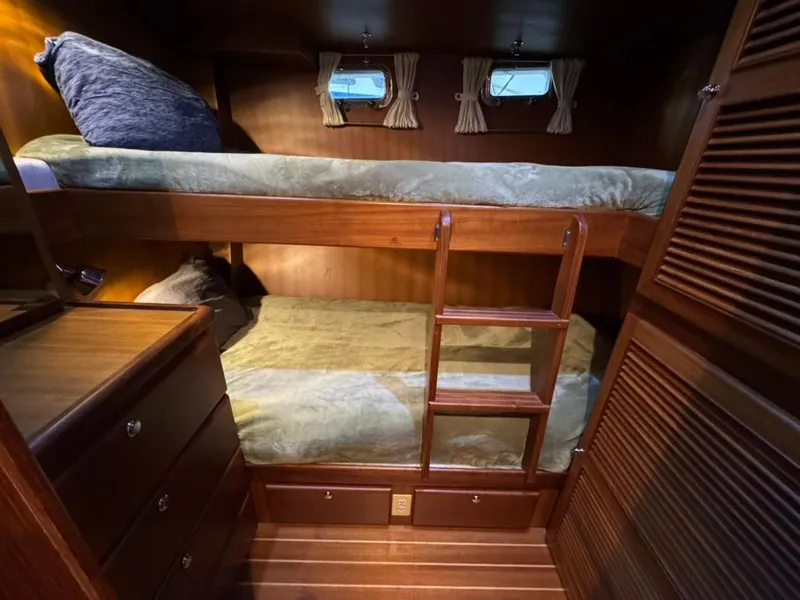 Slide: The Image of Bunk beds in 2010 North Pacific 43 Pilothouse cabin with wooden interior and small windows. - 17