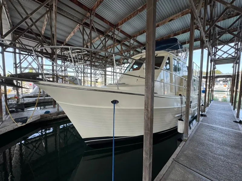 Slide: The Image of 2010 North Pacific 43 Pilothouse boat docked in a covered marina. - 2