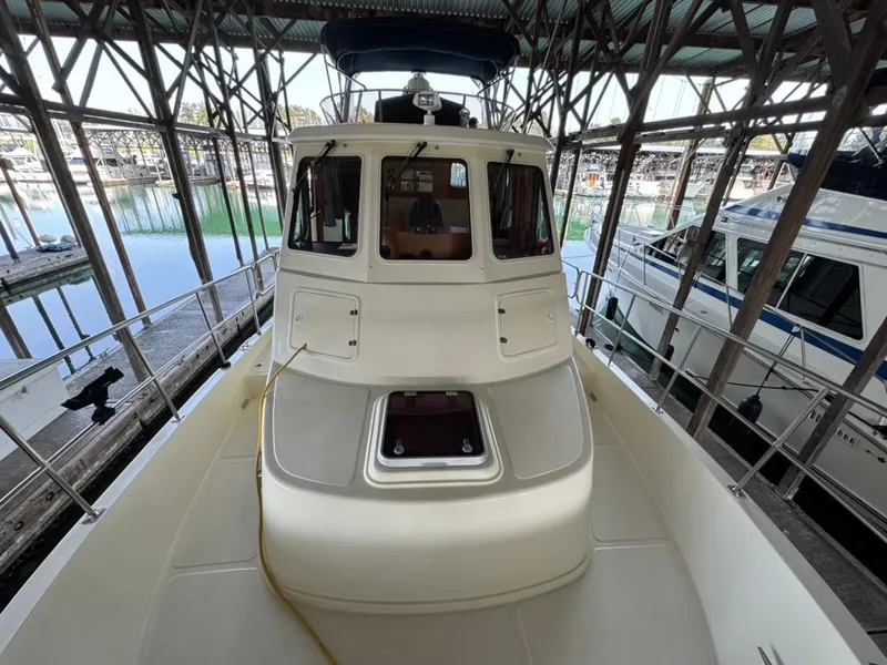 Slide: The Image of 2010 North Pacific 43 Pilothouse boat docked in a marina under a covered structure. - 23