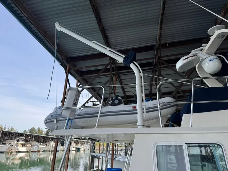 Slide: The Image of 2010 North Pacific 43 Pilothouse with dinghy on deck under marina roof. - 4