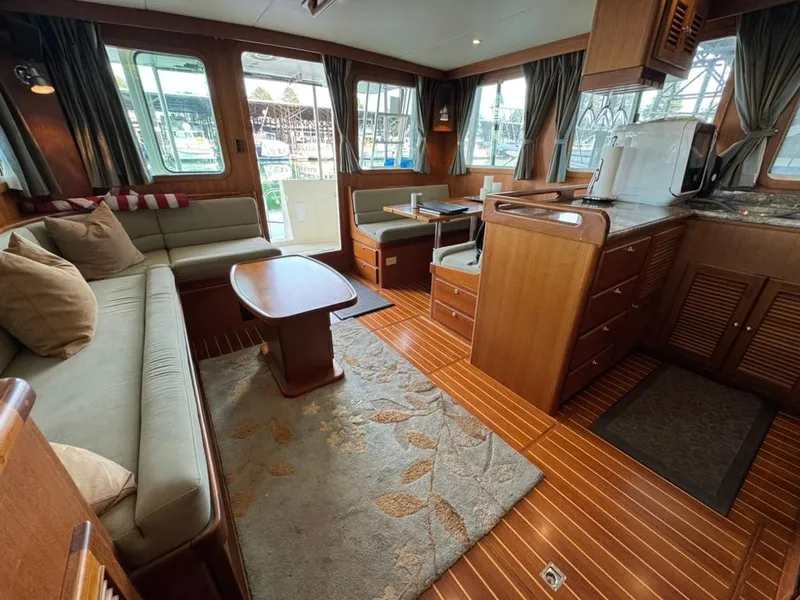 Slide: The Image of Interior of 2010 North Pacific 43 Pilothouse with cozy seating and wooden flooring. - 7