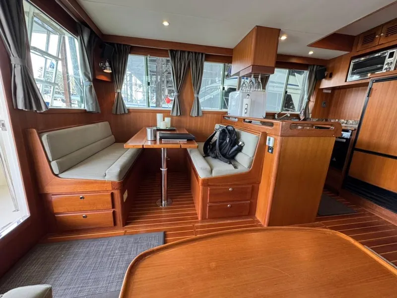Slide: The Image of Interior of 2010 North Pacific 43 Pilothouse with wooden furnishings and dining area. - 8