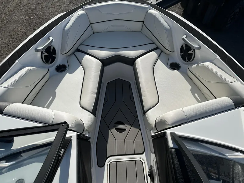 Slide: The Image of 2017 Malibu Response TXi boat interior with white cushioned seating and cup holders. - 14
