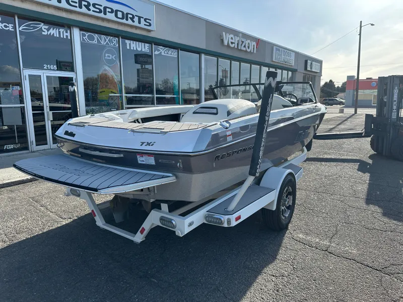 Slide: The Image of 2017 Malibu Response TXi boat on trailer outside a motorsports store. - 3
