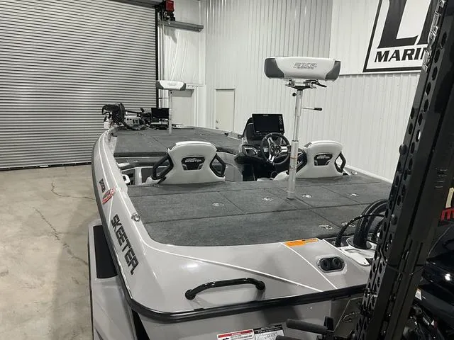 Slide: The Image of 2025 Skeeter FXR21L boat in a garage, featuring dual seats and advanced navigation equipment. - 12