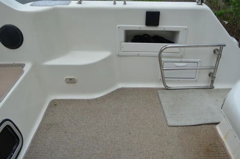 Slide: The Image of 1996 Rinker 300 Fiesta Vee boat interior with carpeted flooring and storage compartment. - 18