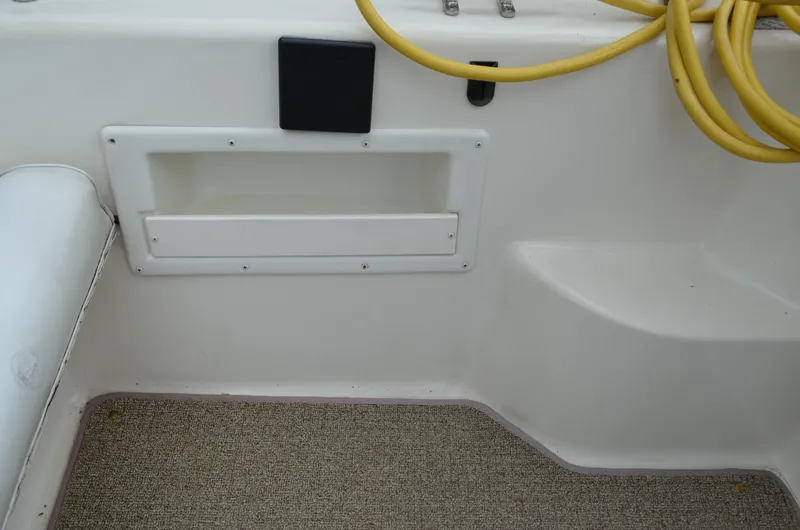 Slide: The Image of Interior of a 1996 Rinker 300 Fiesta Vee boat with yellow hose and storage compartment. - 19