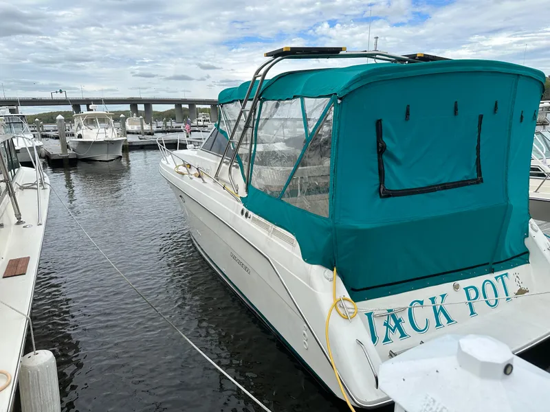 Slide: The Image of 1996 Rinker 300 Fiesta Vee boat docked with teal canopy, overcast sky. - 2