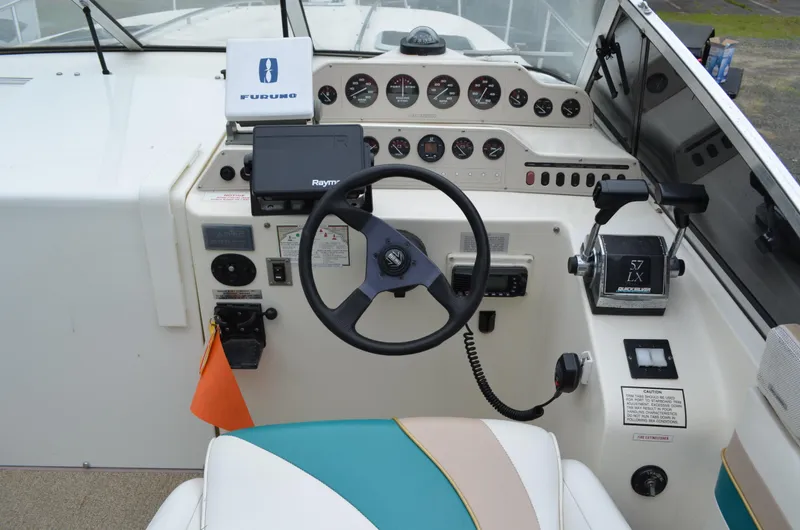 Slide: The Image of Cockpit of 1996 Rinker 300 Fiesta Vee boat with steering wheel and control panel. - 23
