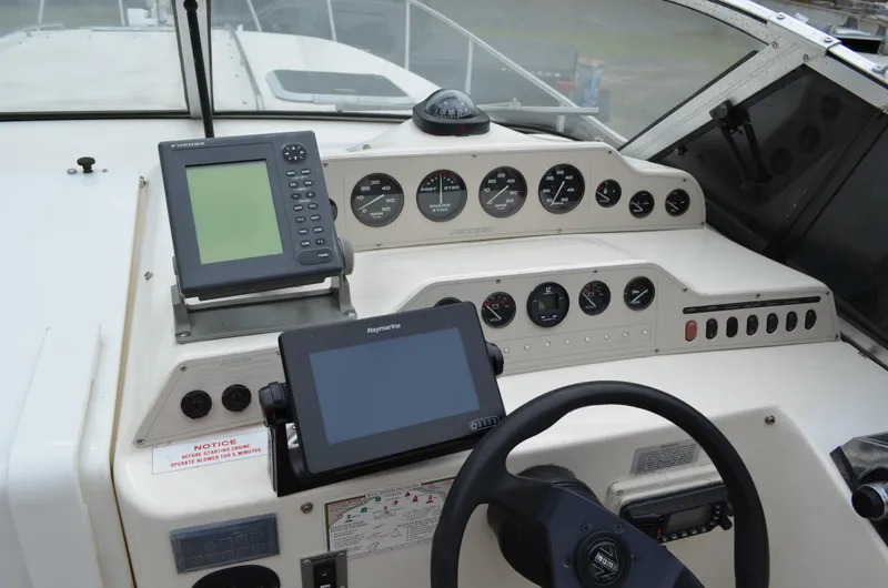 Slide: The Image of 1996 Rinker 300 Fiesta Vee boat dashboard with navigation instruments and steering wheel. - 24